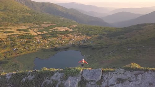Tourist Hiker with a Backpack in Orange Jacket Walking on Mountain Path in Carpathian Mountains