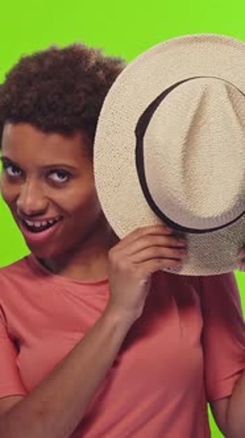 Smiling Woman Poses with Hat on Green Screen