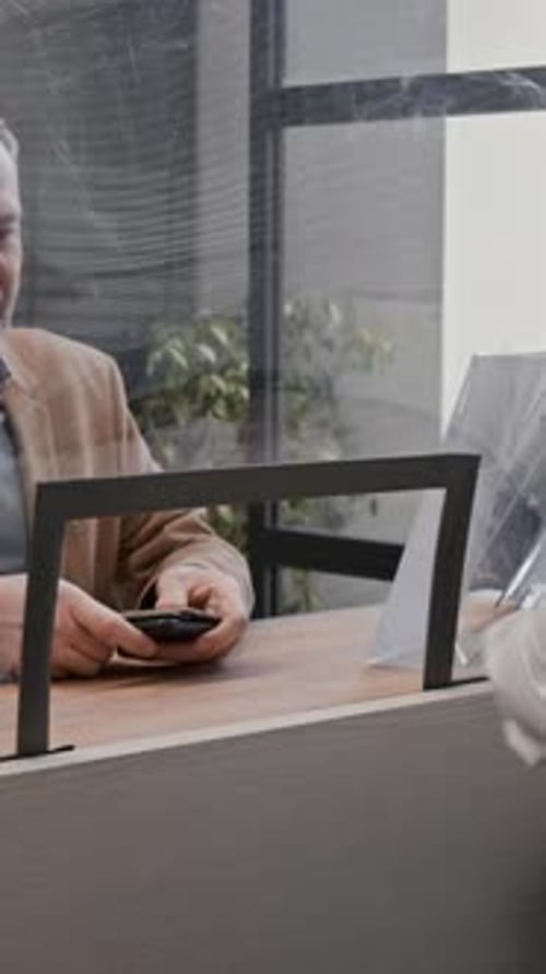 Man Paying Bill at Reception Desk Inside Office