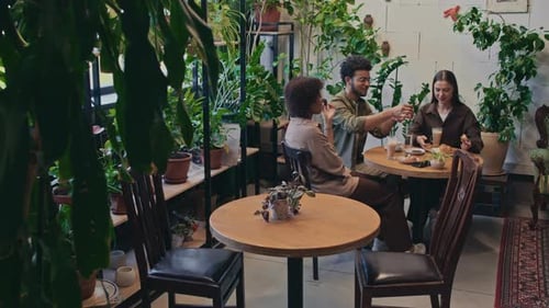 Multiethnic Students Having Lunch at Stylish Green Cafe