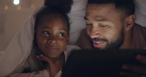 Father and Daughter Watching Tablet at Night