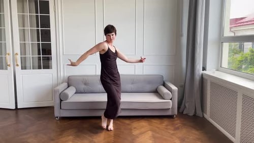 Woman in Black Dress Dancing Barefoot in Living Room