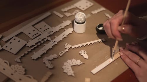 Mélangez avec précision la peinture et organisez les petites pièces laser sur un plan de travail organisé pour le processus d'assemblage