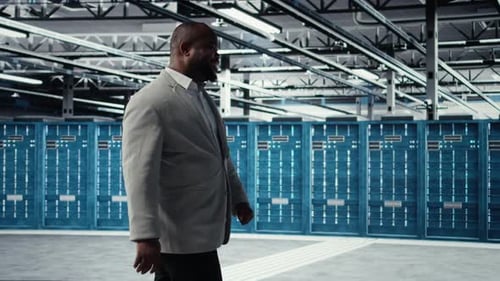 Happy Businessman Walking in Data Center Assessing Capacity Before Investing
