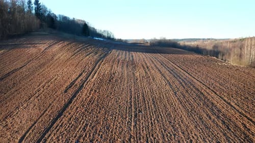 LUFTBILD: Gepflügtes Farmgelände an einem sonnigen Tag in Osteuropa