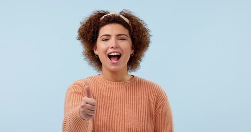 Happy, Gesicht und Daumen hoch von Frau im Studio für Dankeschön, Motivation oder Erfolg auf Blau