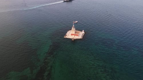 Klares Wasser umgibt den Jungfrauenturm, wenn ein Boot vorbeifährt, und fängt die friedliche Essenz dieses Ortes ein