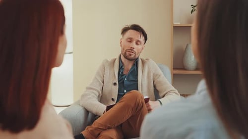 Man Talking to Two Women in Living Room