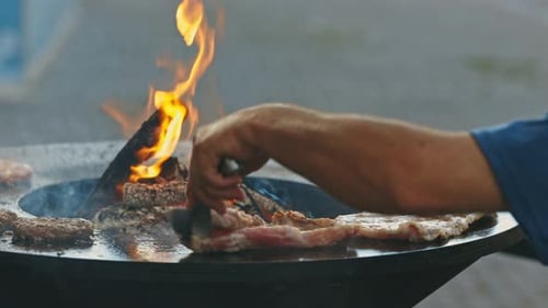 The Chef Cooks Meat and Cutlets on the Grill with an Open Fire
