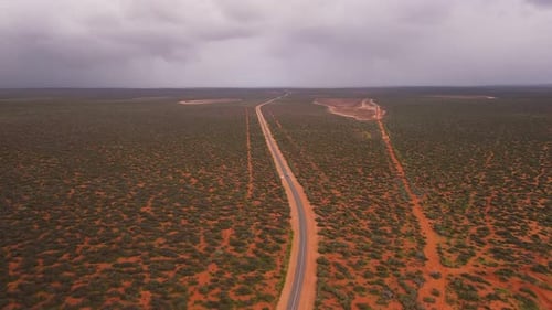 Aerial view of winding desert road through barren landscape, Australia.