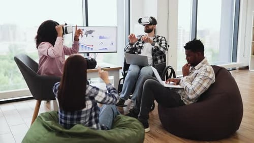 Group of Young Adults Collaborating with Technology in a Modern Workspace
