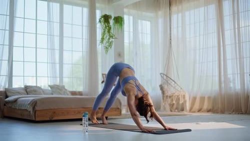 Woman Doing Yoga on Mat in Bright Room
