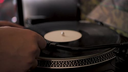 Close-up male hand starting record player, put the needle on record, selective focus. Gramophone and