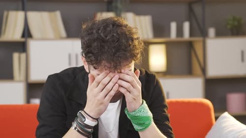 Sad young man crying, grieving.
