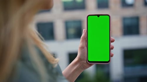 Unrecognizable Woman Watching Greenscreen Smartphone in Modern City Closeup