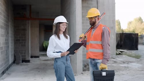 Construction workers discussing project details on-site at a building under construction