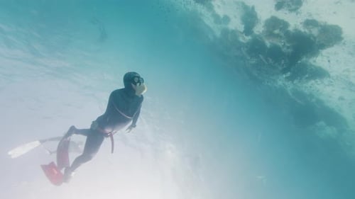 Male Freediver Descends Into the Depth in the Tropical Sea Over the Coral Reef