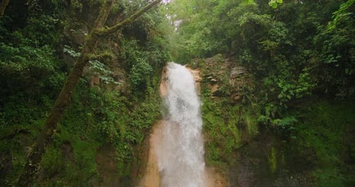 Powerful waterfall at Costa Rica Blue Falls surrounded by lush green rainforest