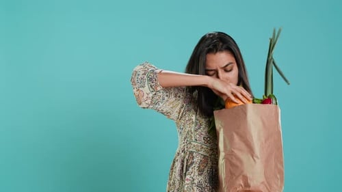 Mujer con una bolsa de papel ecológica en las manos mirando un pimiento
