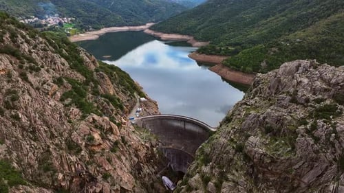Scenic view of a dam and reservoir surrounded by mountains