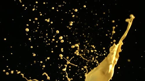 Golden Paint Splatter Against Black Background Slow Motion