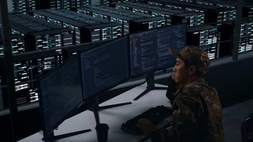 Side View Of Bored Asian Military Write Code In Data Center