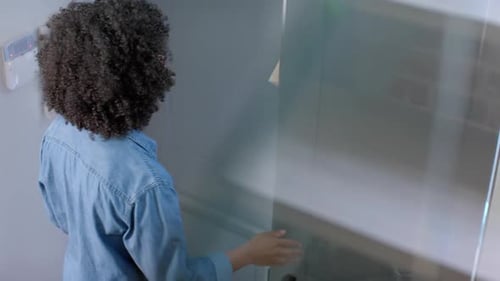 Happy biracial woman receiving parcel at home, slow motion