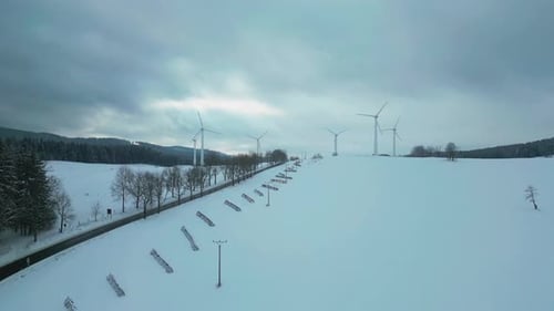 Snowy Winter Landscape with Wind Turbines Aerial Shot