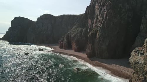 Dramatic High Angle View of Dark Coastal Cliffs and Waves
