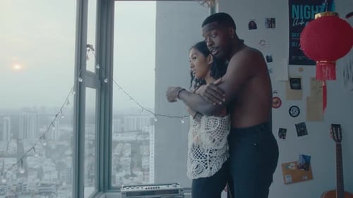 Loving Couple Embracing Indoors Near a Window