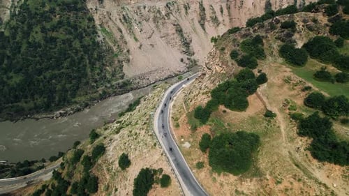 Motorcyclists Driving Along Mountain Serpentine Drone View