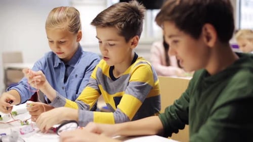 Children engineering robotics project at school classroom table