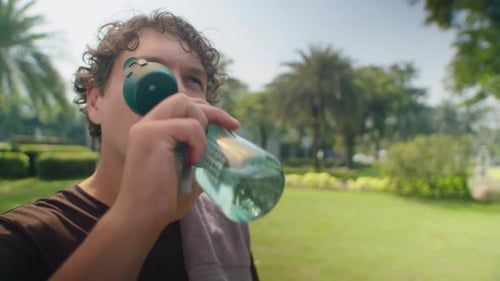 Man Drinking Water after Training in Park