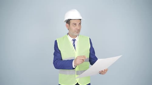Engineer Reviews Construction Blueprints Wearing Safety Gear