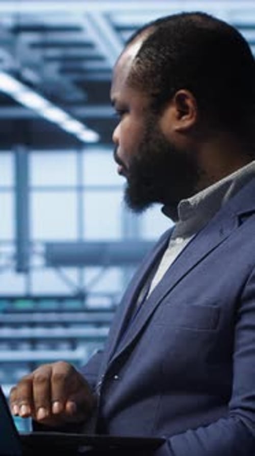 Desenvolvedor de software de vídeo vertical monitorando o consumo de energia do hardware do hub do servidor com laptop