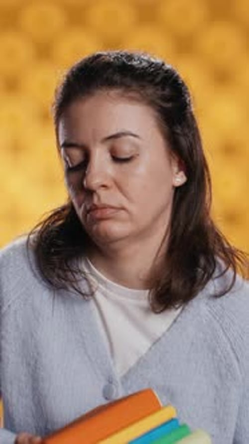 Vertical Video Exhausted Woman Yawning Holding Heavy Stack of Books Needed for School Exam