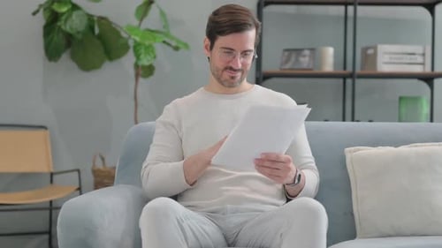 Man on Couch Celebrating Reading Good News