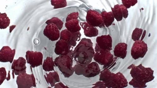 Juicy Raspberry Beverage Spinning Top View. Closeup Transparent Fruit Cocktail Funnel Inside Glas...
