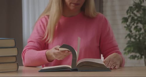 Woman Turns Pages in a Book Indoors