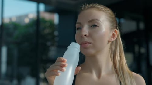 Woman Drinking Water After Workout at the Gym