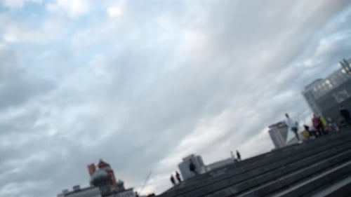 Tilting view of city stairs with people walking on a crowded urban street