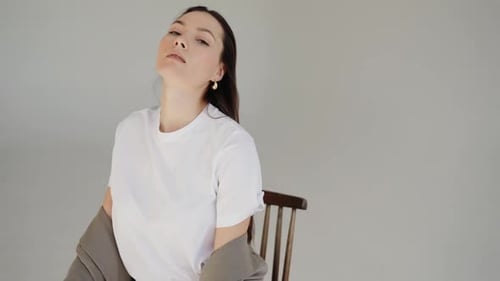 Elegant Woman Posing in Studio in Fashionable Outfit
