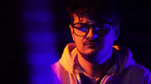 Portrait of Programmer or Hacker Working on Computer in Dark Room, Close Up