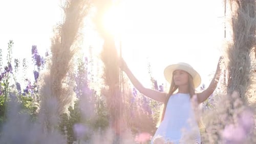 A Beautiful Young Woman is Riding on a Swing at Sunset She is Wearing a Beautiful Dress and a Hat