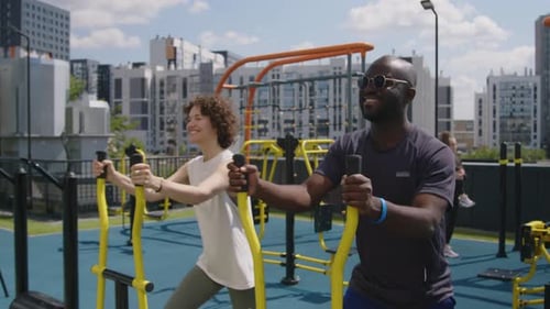 Fellow Athletes Exercising on Cross Trainer at Outdoor Rooftop Gym