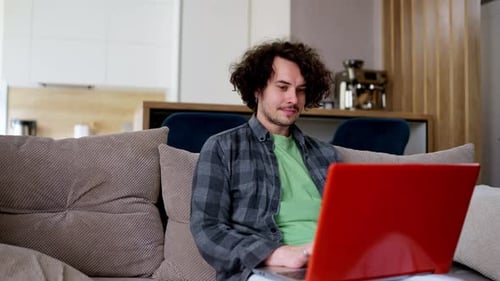 Man Using Laptop on Couch at Home