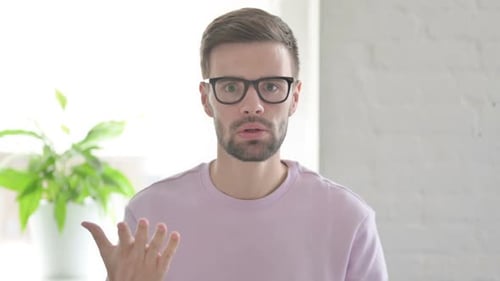 Man Gesturing and Speaking to the Camera