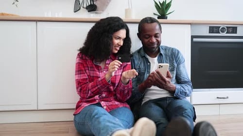 Smiling Couple Online Shopping in Modern Kitchen