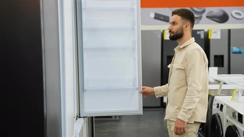 Customer Examining Refrigerator in Electronics Store