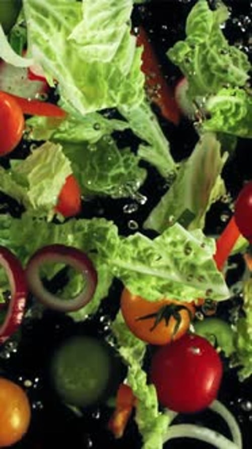 Chopped Vegetables with Drops of Water Fly Up and Fall Down Top View Filmed on a Highspeed Camera at